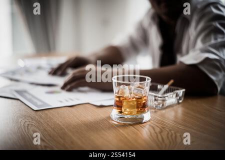 Businessman drinking from stress at workplace Stock Photo