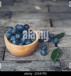 Fresh plums in wooden bowl on old wooden background Stock Photo