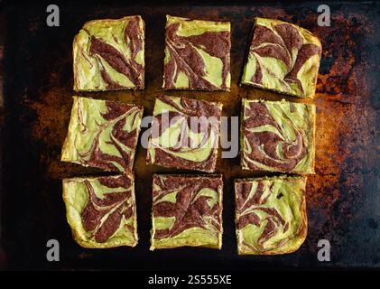 Matcha Cheesecake Brownies on a Rustic Sheet Pan: Green tea cream cheese swirled brownies cut into squares on a vintage baking pan Stock Photo