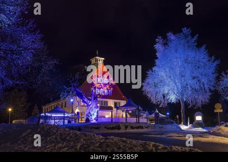 Illuminated Buehlhaus at night, in front of it the old Buehl beech and the new Buehl beech (Fagus), Eibenstock in winter, Erzgebirge, Saxony, Germany Stock Photo