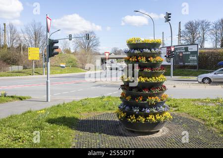 Cascading plant pot with spring planting on Dresdner Strasse, corner of Am Gueterbahnhof, railway bridge in the background, Coswig, Saxony, Germany, E Stock Photo