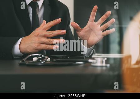 smart medical doctor working with smart phone and digital tablet computer and stethoscope on wood desk in modern office Stock Photo