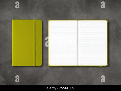 Olive green closed and open lined notebooks mockup isolated on dark concrete background. Olive green closed and open lined notebooks on dark concrete Stock Photo
