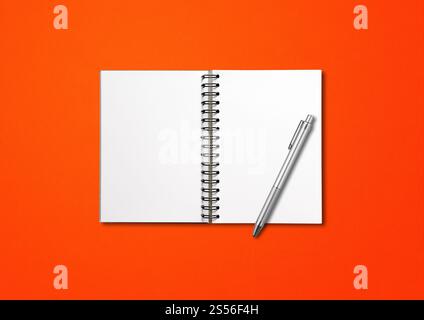 Blank open spiral notebook mockup and pen isolated on red background. Blank open spiral notebook and pen isolated on red Stock Photo
