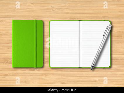Green closed and open lined notebooks with a pen. Mockup isolated on wooden background. Green closed and open lined notebooks with a pen on wooden Stock Photo