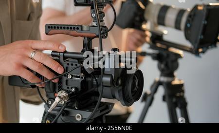 Video camera. Professional filming. Content production unrecognizable backstage studio. Media team working with shooting equipment. Stock Photo