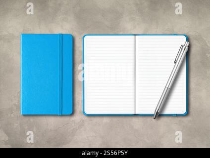 Blue closed and open lined notebooks with a pen . Mockup isolated on concrete background. Blue closed and open lined notebooks with a pen on concrete Stock Photo