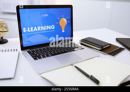E-learning Education Internet Networking . Young businesswoman sitting and used laptop with inscription on screen e-learning. Online education Stock Photo