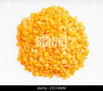 top view of pile of raw split red lentils close up on gray ceramic plate Stock Photo
