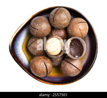 top view of sawn and shelled macadamia nuts in ceramic bowl isolated on white background Stock Photo