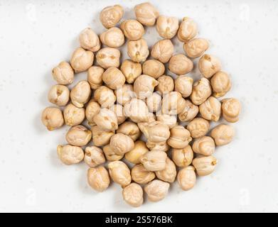 top view of pile of raw dried chickpea seeds close up on gray ceramic plate Stock Photo