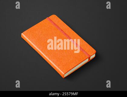 Orange closed notebook mockup isolated on black. Orange closed notebook isolated on black Stock Photo
