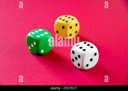 Three colorful dices isolated on pink background Stock Photo