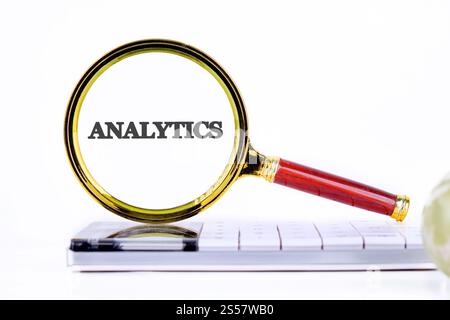 Using a magnifying glass to emphasize the importance of analytics in technology and business strategy for informed decision making. Stock Photo