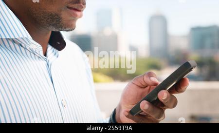 Professional Individual Engages with Smartphone Outdoors in Urban Setting Stock Photo