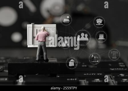 industry concept-miniature engineer working with drafting table on laptop computer with industry diagram Stock Photo