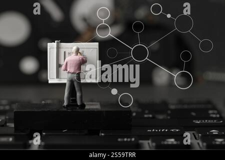 industry concept-miniature engineer working with drafting table on laptop computer with network diagram Stock Photo