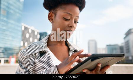 Professional Woman Using a Tablet Outdoors in an Urban Environment Stock Photo