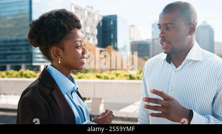 Professional Colleagues Engaged in a Business Conversation Outdoors in a Modern Cityscape Setting Stock Photo