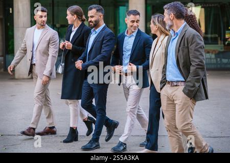 Business Team Walking and Talking Outdoors in Urban Setting Stock Photo
