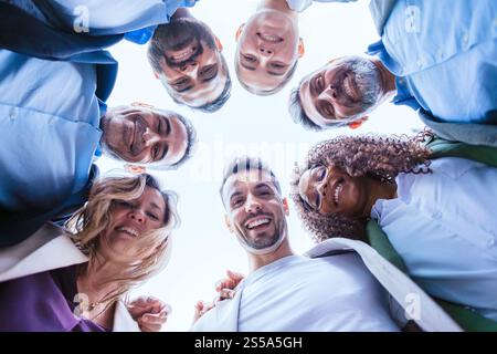 Group of businesspeople smiling in a huddle outdoors Stock Photo