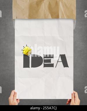 yellow crumpled paper on hand drawn IDEA on poster background as creative concept Stock Photo