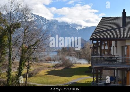 Raw photo of beautiful landscape of a lake, a house, mountains and nature. taken in the a cold weather in early spring in Switzerland. Stock Photo