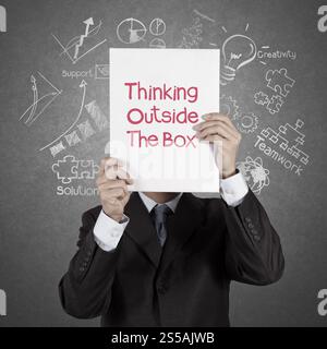 businessman hand show book of thinking outside the box as concept Stock Photo
