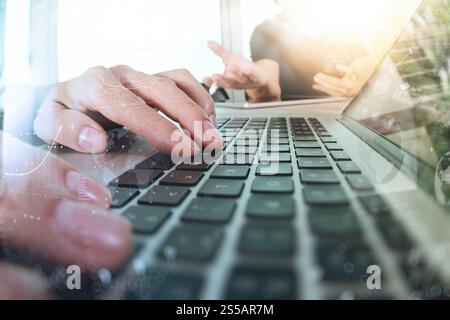 two colleagues Website designer working digital tablet and computer laptop with smart phone and digital design diagram on wooden desk as concept Stock Photo