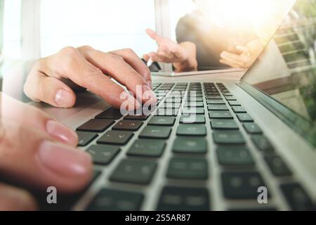 two colleagues Website designer working digital tablet and computer laptop with smart phone and digital design diagram on wooden desk as concept Stock Photo