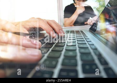 two colleagues Website designer working digital tablet and computer laptop with smart phone and digital design diagram on wooden desk as concept Stock Photo