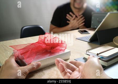 business creative designer hand giving his colleague Christmas present in office Stock Photo