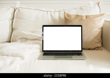 Close-up of an open laptop with a blank screen on a sofa in a stylish living room Stock Photo