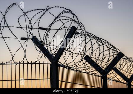 Symbolic image of security, S-wire coils, NATO wire, on a fence crown, demarcation of a property, prevention of unauthorised access, strip steel wire Stock Photo