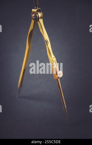 Old vintage pair of compasses on a dark background. Old vintage pair of compasses on dark background Stock Photo