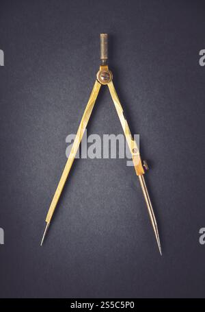Old vintage pair of compasses on a dark background. Old vintage pair of compasses on dark background Stock Photo