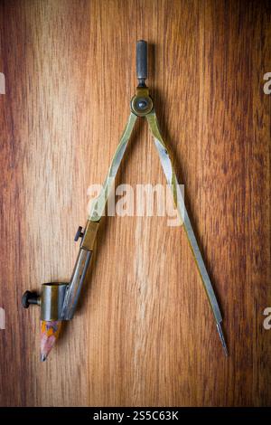 Old vintage pair of compasses on a wooden table background. Old vintage pair of compasses on a wooden background Stock Photo
