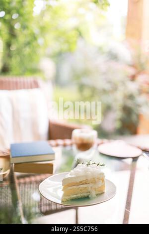 Coconut Cake and Coffee in a cafe on the blur background. traditional dessert Sliced of delicious coconut layer cake. Stock Photo