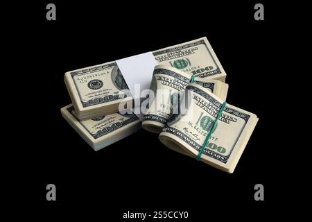 Two bitcoins lies on a pile of dollar bills on the background of a monitor depicting a binary code of bright green zeros and one units on a black Stock Photo