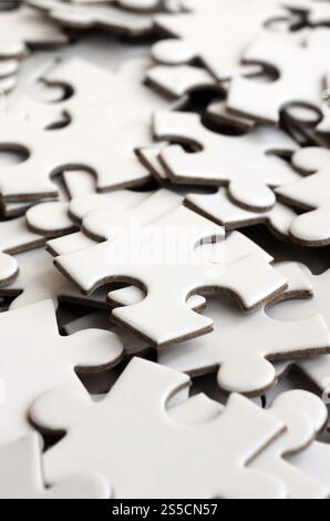 Close-up of a pile of uncompleted elements of a white puzzle. A huge number of rectangular pieces from one large white mosaic Stock Photo