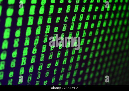Macro shot of a glitch on the monitor of an office computer. The concept of introducing a virus into a personal data keeper. Stream of random green Stock Photo