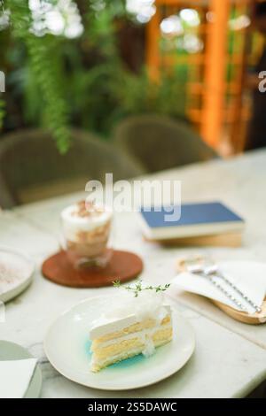 Coconut Cake and Coffee in a cafe on the blur background. traditional dessert Sliced of delicious coconut layer cake. Stock Photo