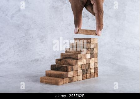 Stacking wooden blocks is at risk in creating business growth ideas. Stock Photo