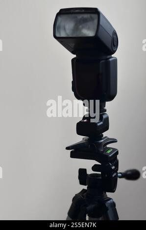 External photographic flashlight gun is mounted on the remote wireless control radio trigger set, which stands on a tripod. lighting equipment for Stock Photo