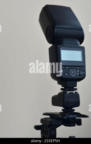 External photographic speedlight gun is mounted on the multichannel sync trigger set on a tripod. lighting equipment for studio photography. Set of Stock Photo