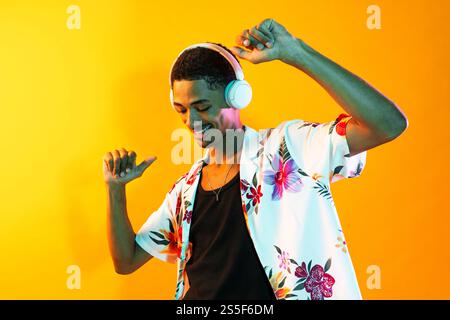 African man young portrait in studio on colorful background - Cool black young male with stylish attire posing , creative colored lighting Stock Photo