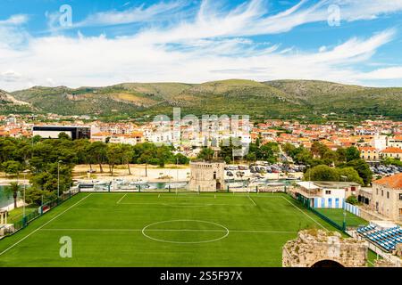 Elevated view of a football stadium with a town and mountains in the background under a clear blue sky, Trogir, Croatia Stock Photo