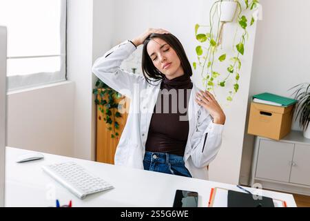 Young professional healthcare female doing stretching exercise workout at office Stock Photo