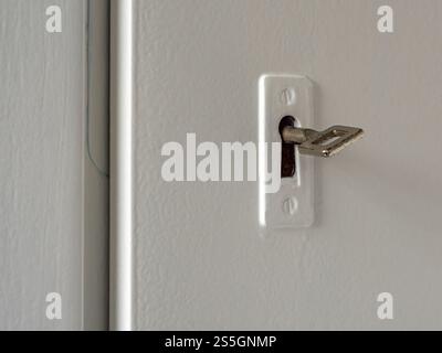Key Inserted in White Door Lock – Close-Up on Security Concept Stock Photo