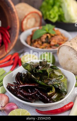 Spicy pork chops in a white dish consisting of lemons, chilies, and side dishes. Selective focus Fried Dried Chilies. Stock Photo